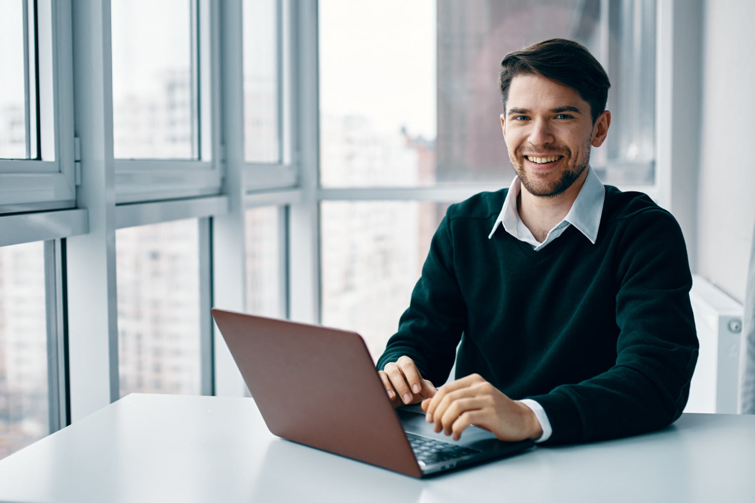 young-man-with-laptop-business-suit-working-office-home-background-window-interviewing-online